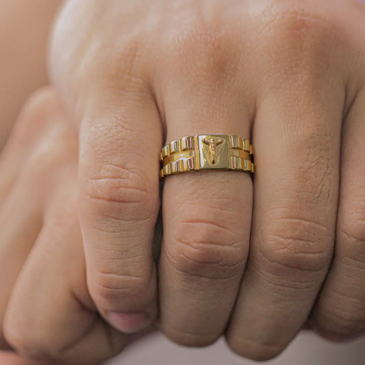 Mano de hombre con anillo Armis con cristo en el centro en oro amarillo de 18 quilates, hecho en Joyería Caracas. 