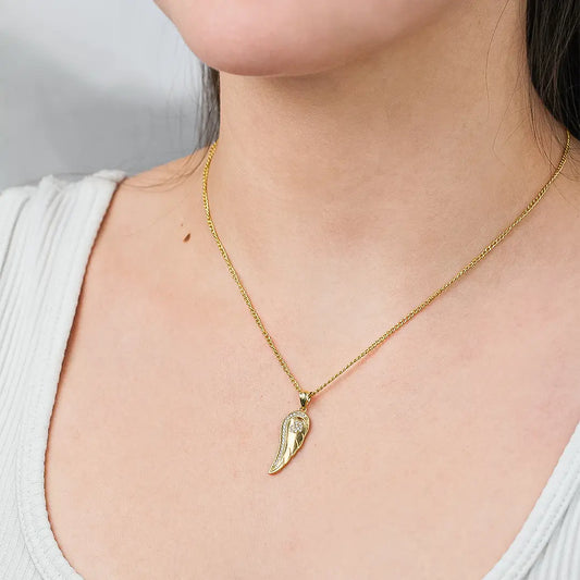 Cuello de mujer con cadena y dije con forma de ala en oro amarillo de 18 quilates con cristales de color blanco, hecho en Joyería Caracas. 