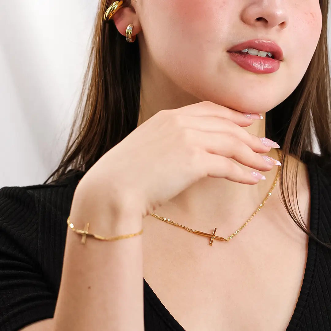 Cuello de mujer usando gargantilla con forma de cruz en oro amarillo de 18 quilates, hecho en Joyería Caracas. 