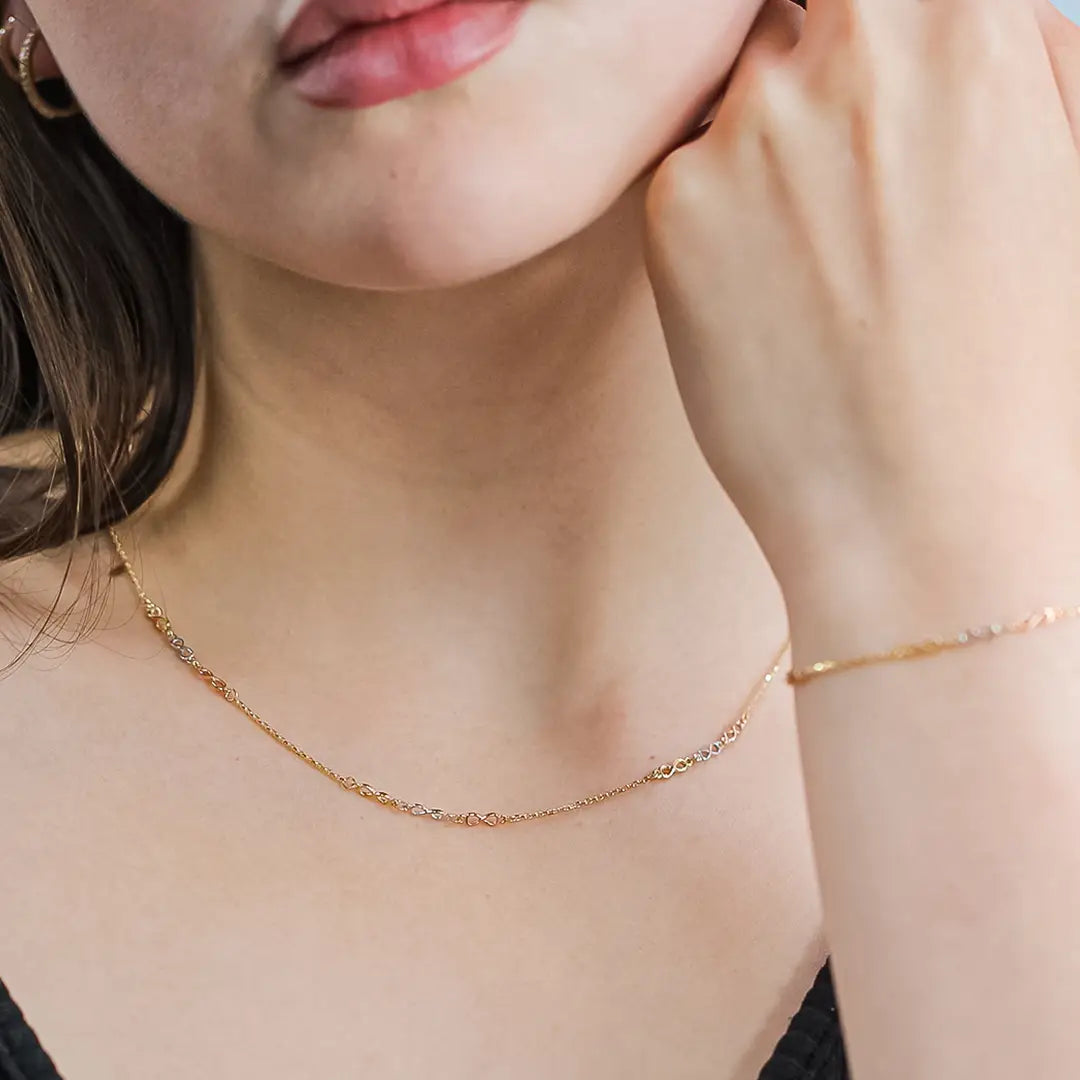 Cuello de mujer usando gargantilla con infinitos en oro amarillo, blanco y rosa de 18 quilates, hecho en Joyería Caracas. 
