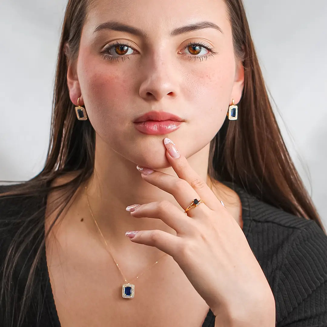 Cuello de mujer usando gargantilla con dije en oro amarillo de 18 quilates con cristal cuadrado de color azul en el centro con cristales de color blanco alrededor, hecho en Joyería Caracas.  