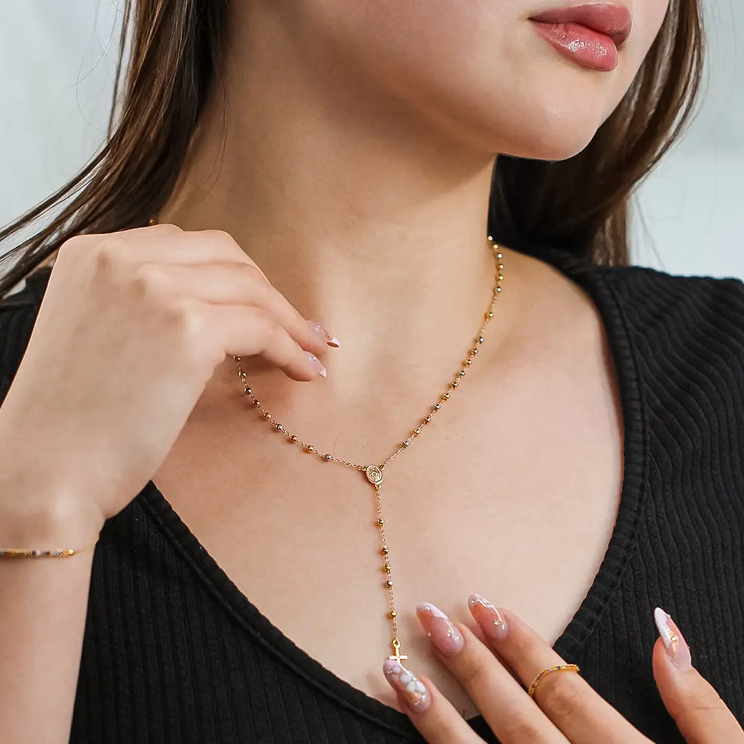 Cuello de mujer con rosario de esferas lisas en oro amarillo, blanco y rosa de 18 quilates, hecho en Joyería Caracas. 