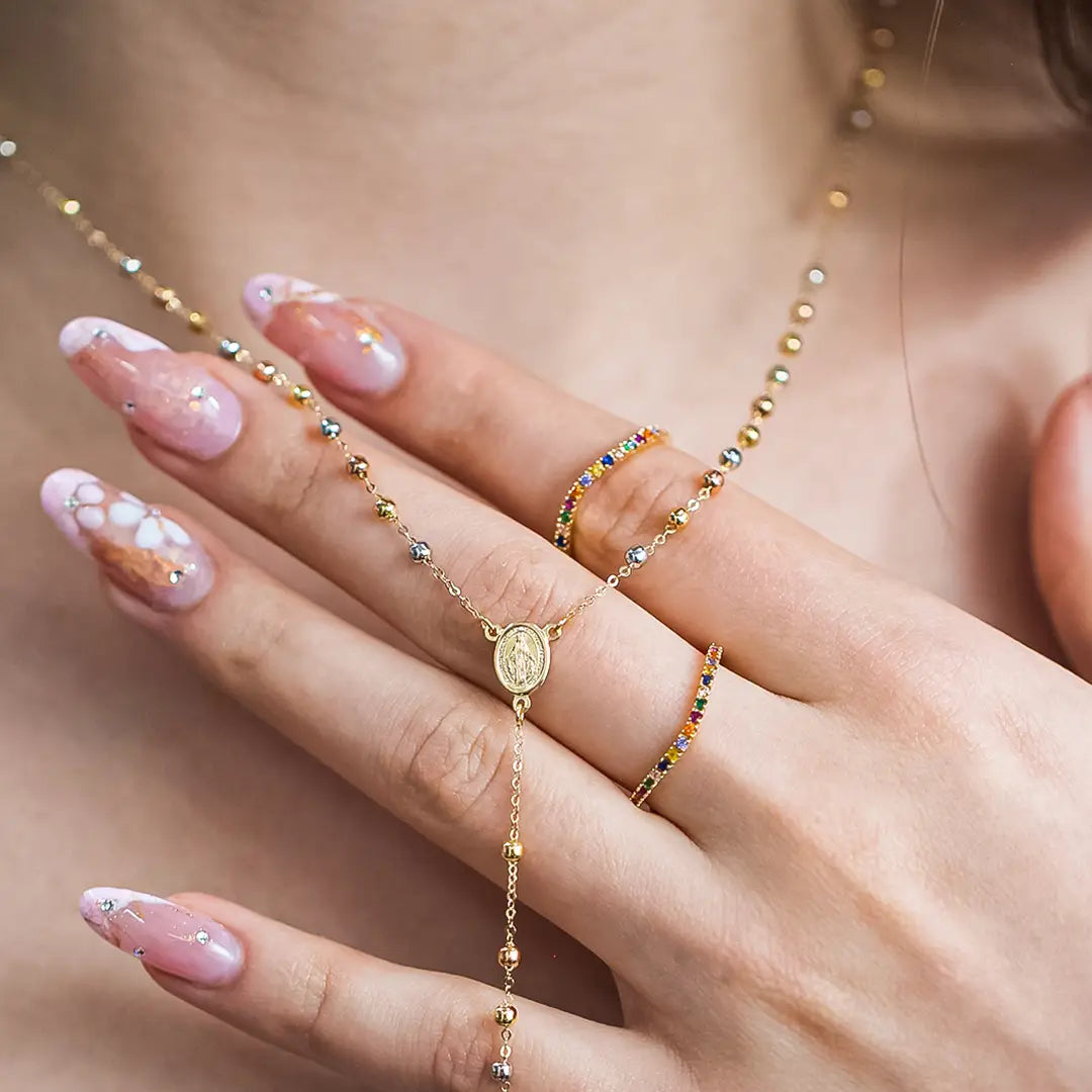 Cuello de mujer con rosario de esferas lisas en oro amarillo, blanco y rosa de 18 quilates, hecho en Joyería Caracas. 