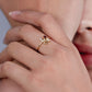 Mano de mujer usando anillo con la palabra Love en oro amarillo de 18 quilates con cristales de color blanco y rojo, hecho en Joyería Caracas. 