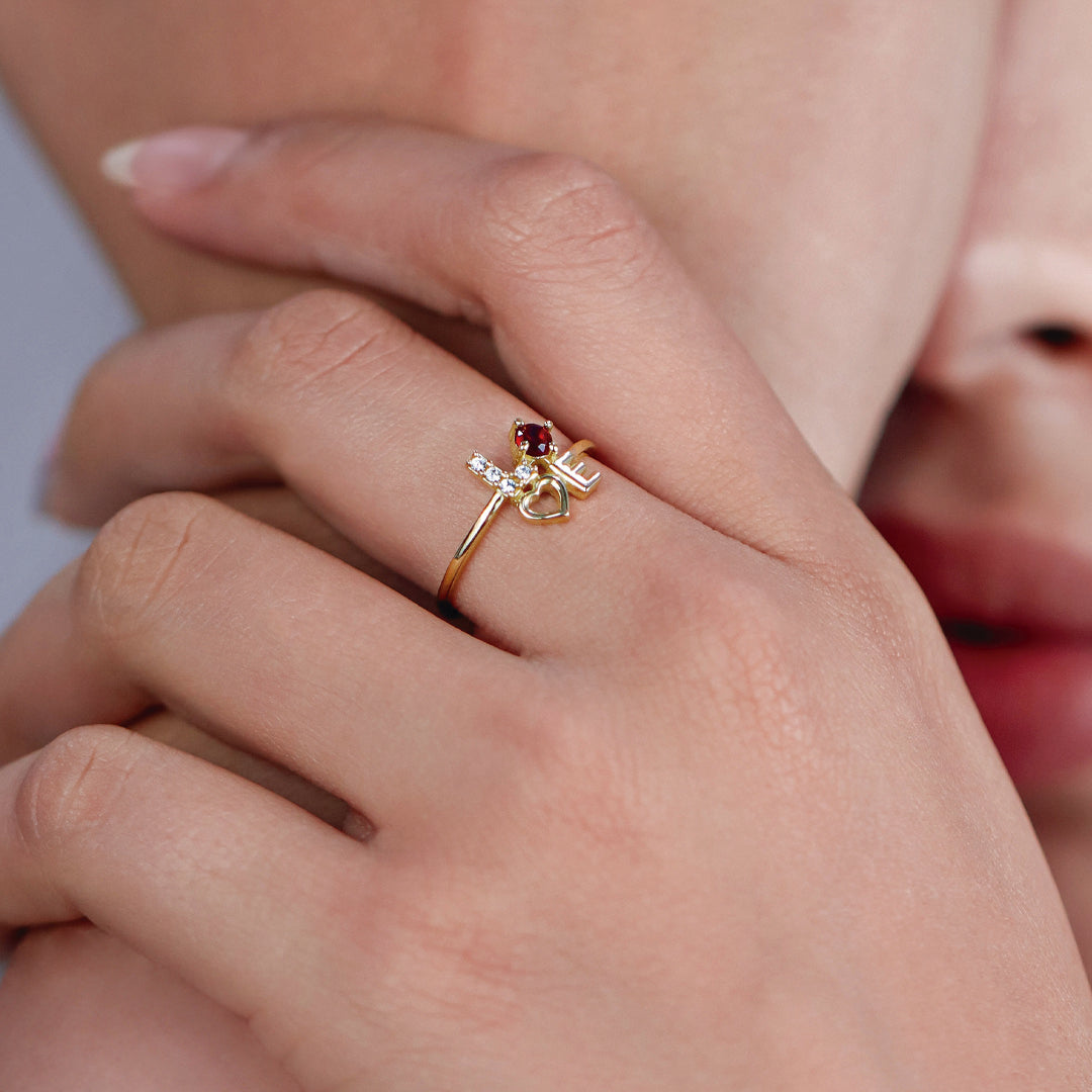 Mano de mujer usando anillo con la palabra Love en oro amarillo de 18 quilates con cristales de color blanco y rojo, hecho en Joyería Caracas. 