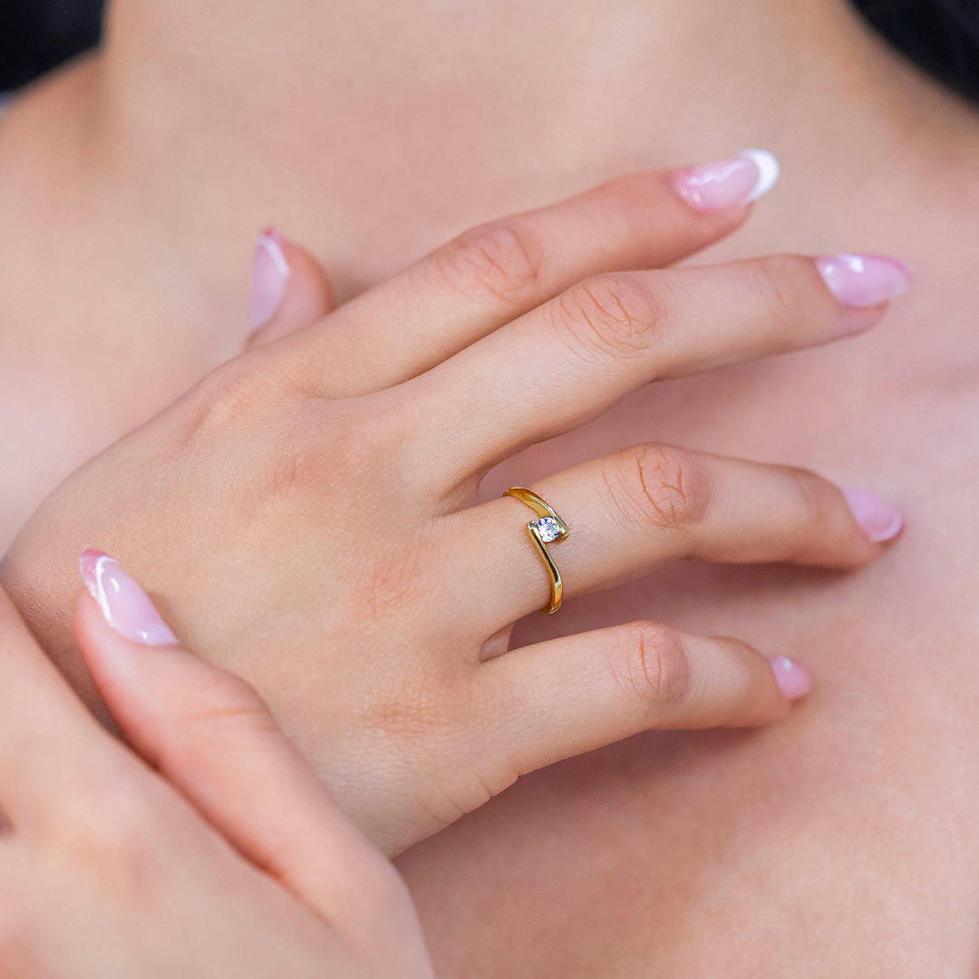 Mano de mujer con anillo en oro amarillo de 18 quilates con cristal de color blanco, hecho en Joyería Caracas. 
