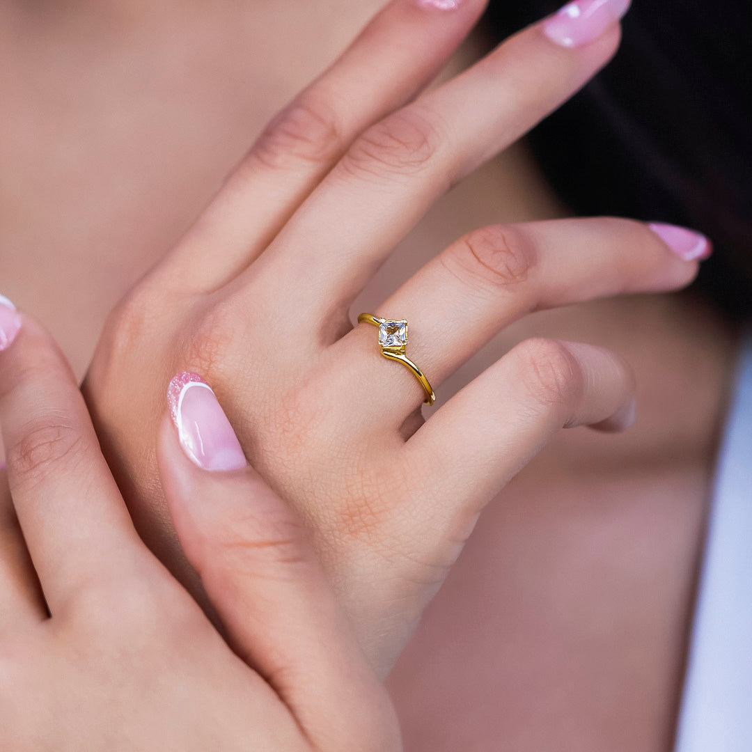 Mano de mujer con anillo en oro amarillo de 18 quilates con cristal de color blanco en el centro, hecho en Joyería Caracas. 