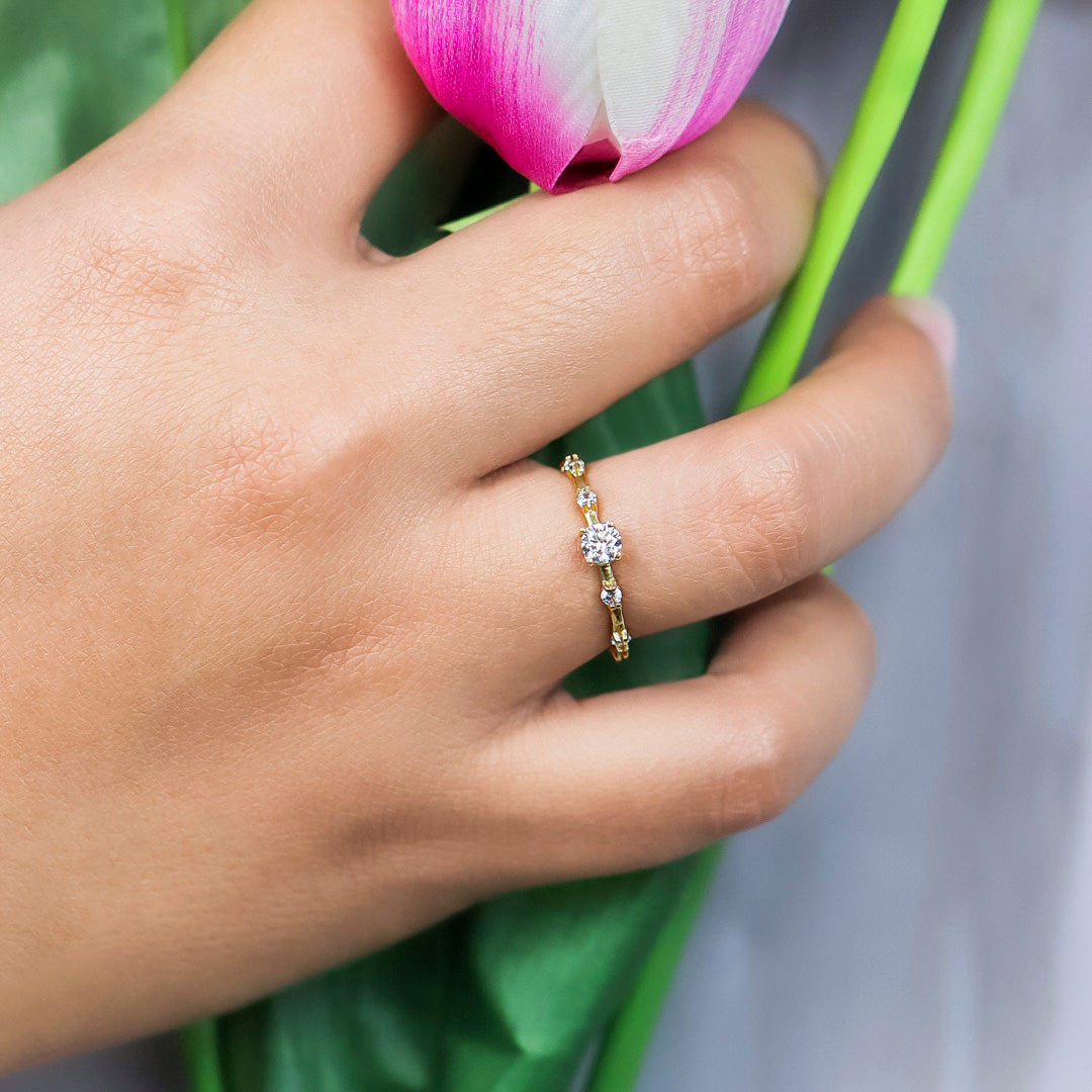 Mano de mujer con anillo en oro amarillo de 18 quilates con cristales de color blanco, hecho en Joyería Caracas. 
