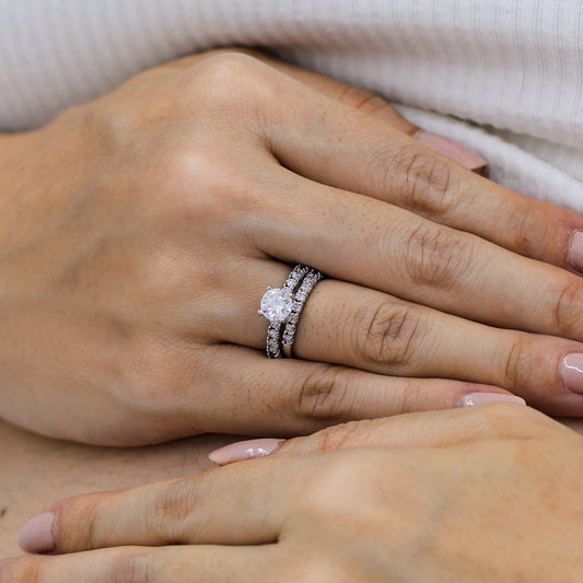 Mano de mujer la cual lleva puesto argolla y pisargolla de matrimonio con cristales blancos y hecha en oro blanco de 18 quilates, hecho en la Joyería Caracas.