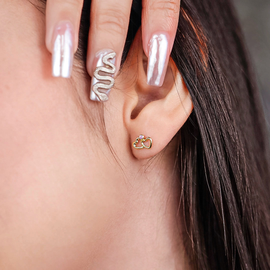 Oreja de mujer con topito de doble corazón listo en oro amarillo  de 18 quilates con cristal de color rosa, hechos en Joyería Caracas. 