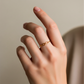 Mano de una mujer usando un anillo con infinito en el centro en oro amarillo de 18 quilates, fabricado en Joyería Caracas.