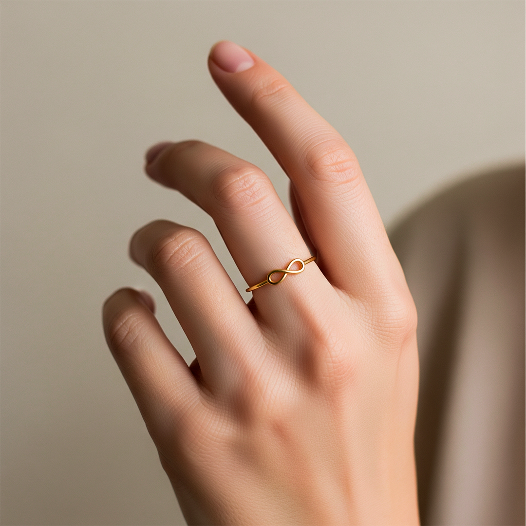Mano de una mujer usando un anillo con infinito en el centro en oro amarillo de 18 quilates, fabricado en Joyería Caracas.