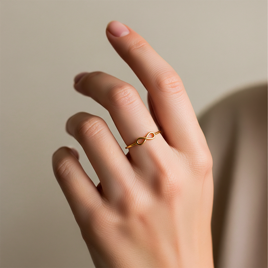 Mano de una mujer usando un anillo con infinito en el centro en oro amarillo de 18 quilates, fabricado en Joyería Caracas.