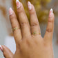 Mano de mujer usando anillo con un ángel en el centro en oro amarillo de 18 quilates, hecho en Joyería Caracas. 
