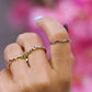 Mano de mujer con anillo asimétrico en oro amarillo de 18 quilates y cristales de distintos colores, hecho en Joyería Caracas. 