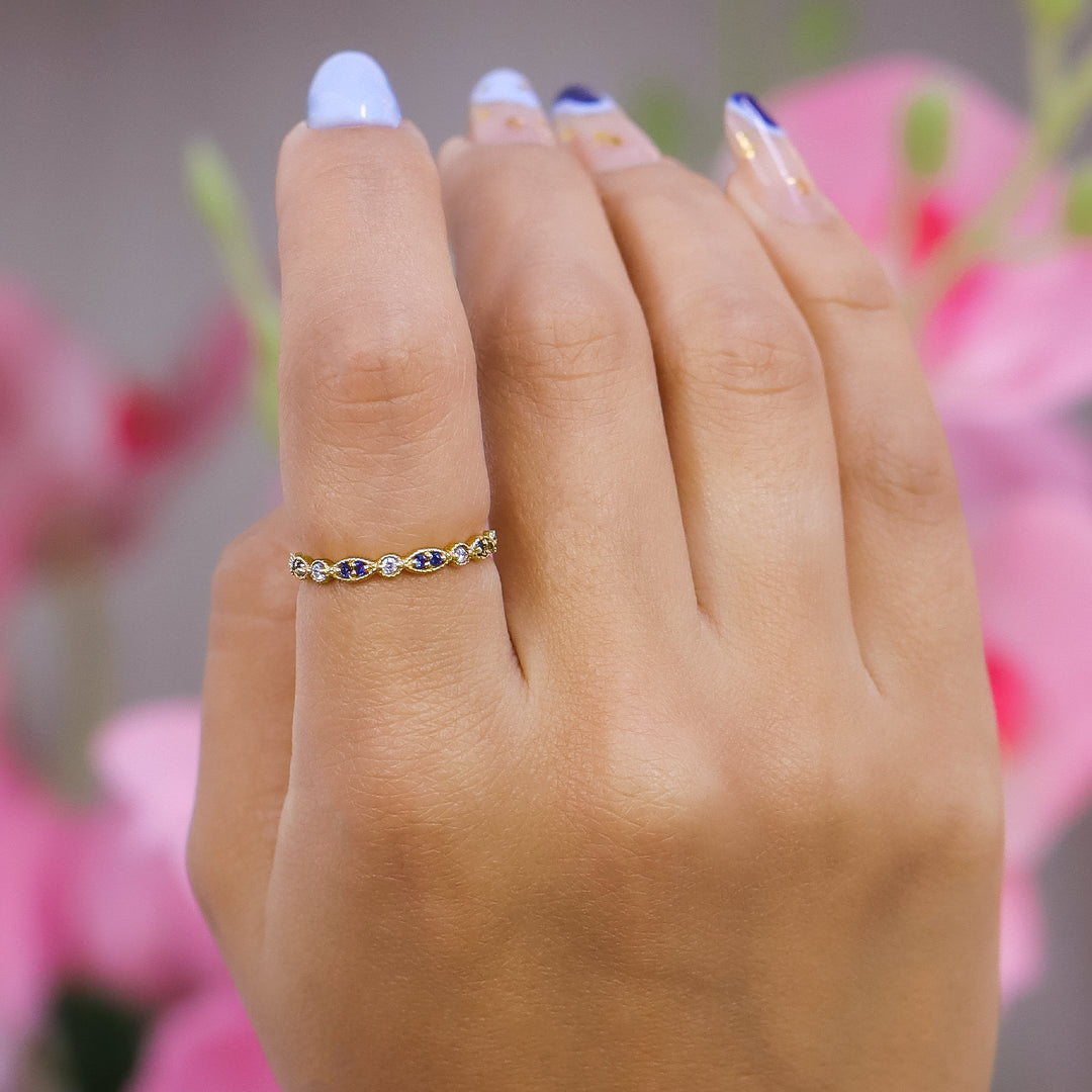 Mano de mujer con anillo en oro amarillo de 18 quilates con cristales de color blanco y azul, hecho en Joyería Caracas. 