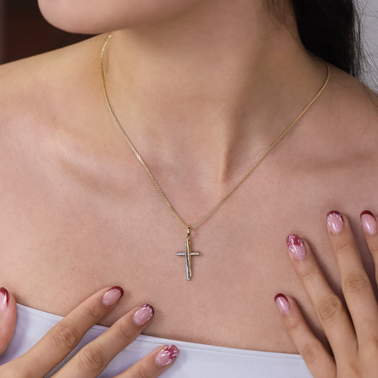 Cuello de mujer con dije de cruz en oro amarillo y blanco de 18 quilates, hecho en Joyería Caracas. 
