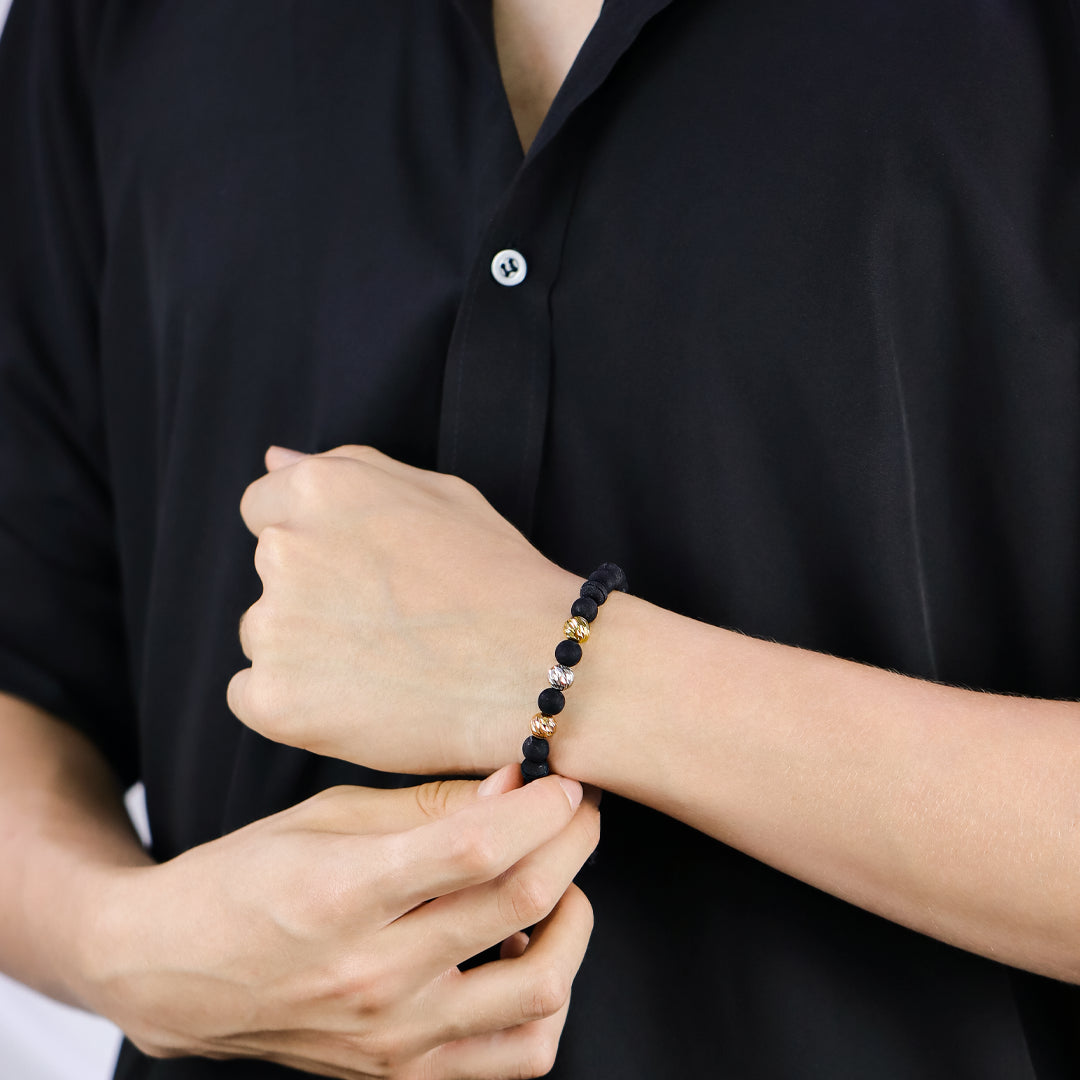 Mano de hombre con pulsera tejida con esferas facetadas en oro amarillo, blanco y rosa #8 de 18 quilates, hecho en Joyería Caracas. 