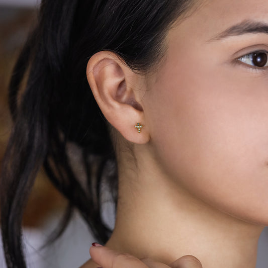 Oreja de mujer con topito en forma de cruz de esferas en oro amarillo de 18 quilates, hechos en Joyería Caracas. 
