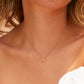 Cuello de mujer usando gargantilla mini cubana con dije pasante en oro amarillo de 18 quilates con cristal de color blanco, hecho en Joyería Caracas. 