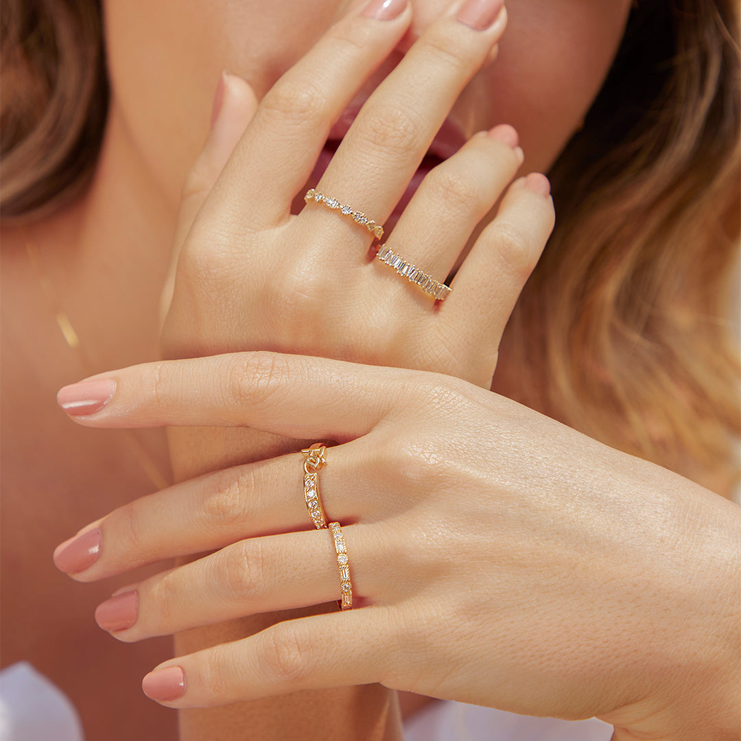 Mano de mujer con anillo en oro amarillo de 18 quilates con piedras preciosas de diamantes de color blanco, hecho en Joyería Caracas. 