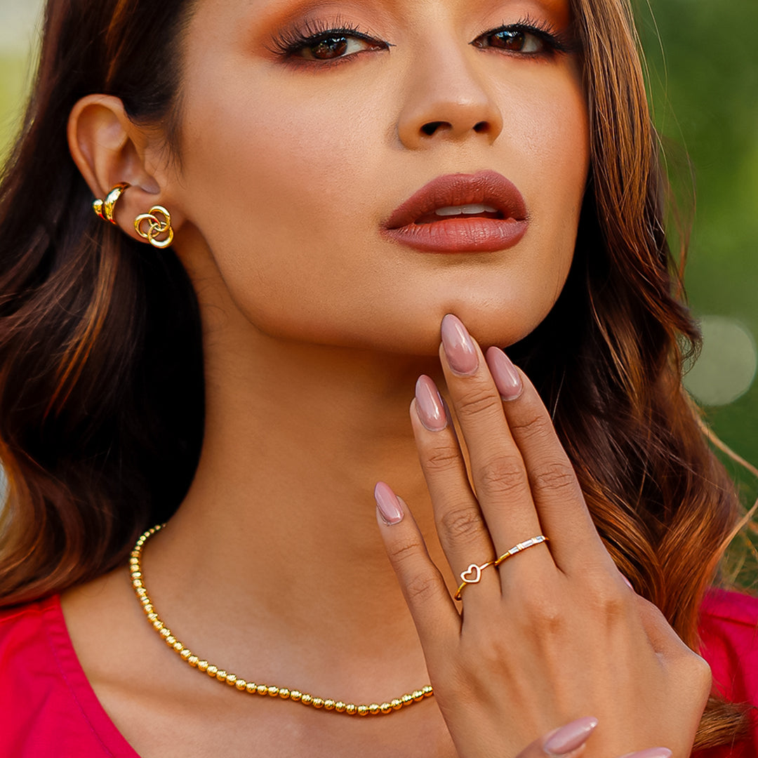 Mano de mujer usando un anillo con corazón en el centro en oro amarillo de 18 quilates, hecho en Joyería Caracas. 