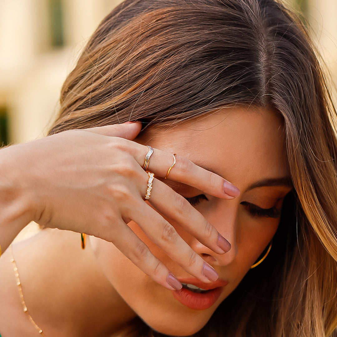 Mano de mujer con anillo en oro amarillo de 18 quilates con piedras preciosas de diamantes de color blanco, hecho en Joyería Caracas. 
