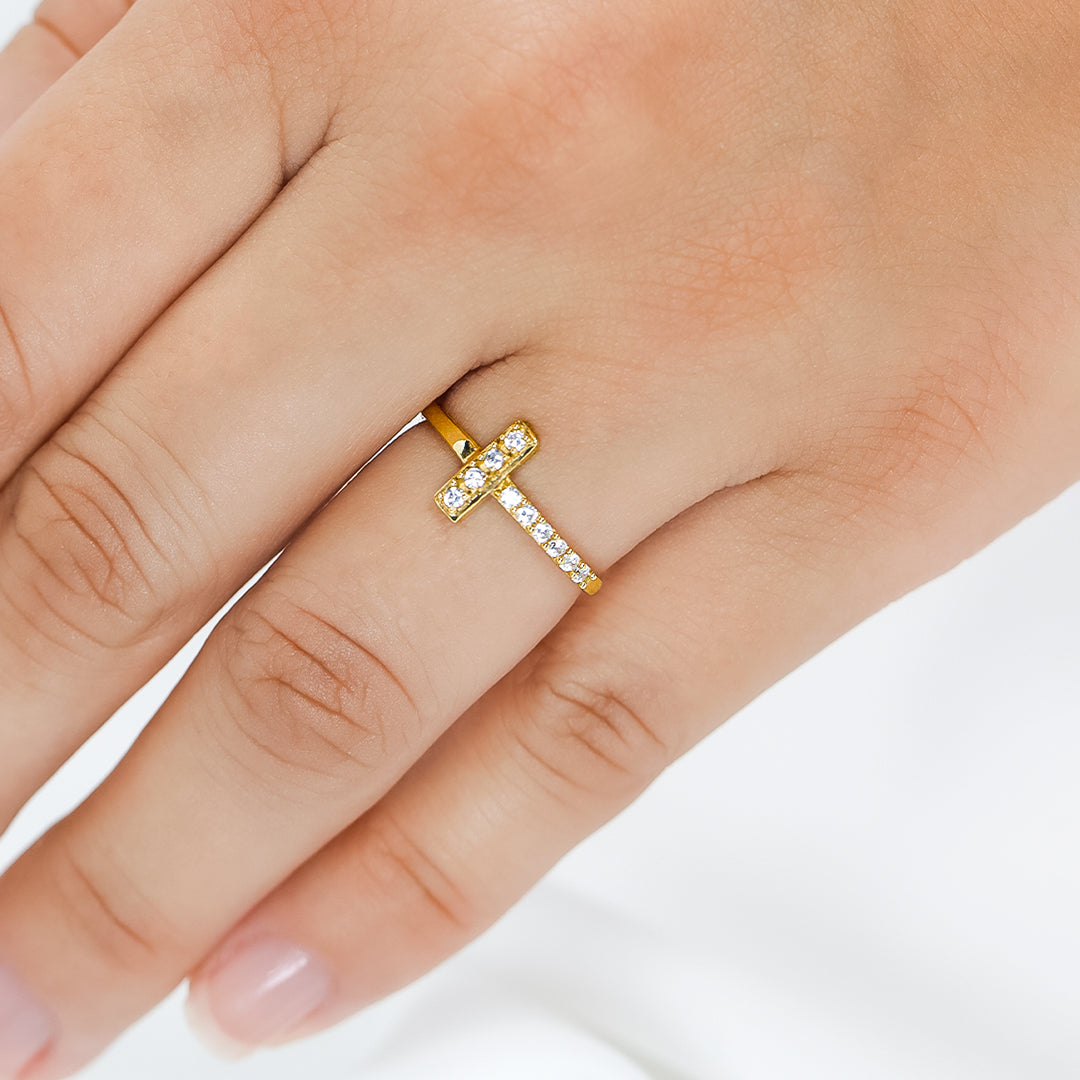 Mano de mujer con anillo en oro amarillo de 18 quilates con cristales de color blanco, hecho en Joyería Caracas. 