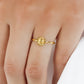 Mano de mujer usando anillo con forma de girasol en el centro en oro amarillo de 18 quilates, hecho en Joyería Caracas. 
