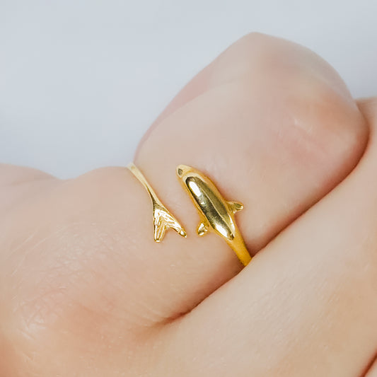 Mano de mujer con anillo en forma de delfín en oro amarillo de 18 quilates, hecho en Joyería Caracas. 