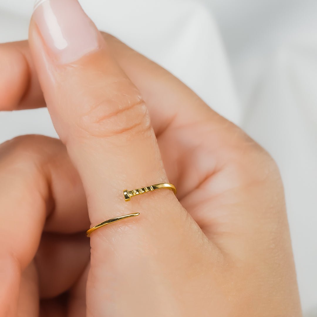 Mano de mujer con anillo en forma de puntilla en oro amarillo de 18 quilates, hecho en Joyería Caracas. 