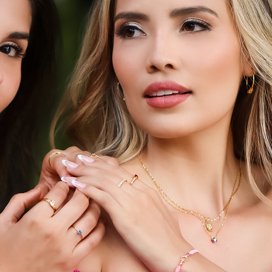 Cuello de mujer usando gargantilla con dije pasante en oro amarillo de 18 quilates con cristal de color morado, hecho en Joyería Caracas. 