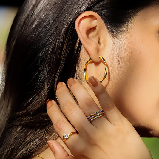 Mano de mujer con anillo en oro amarillo de 18 quilates con cristales de color blanco, hecho en Joyería Caracas. 