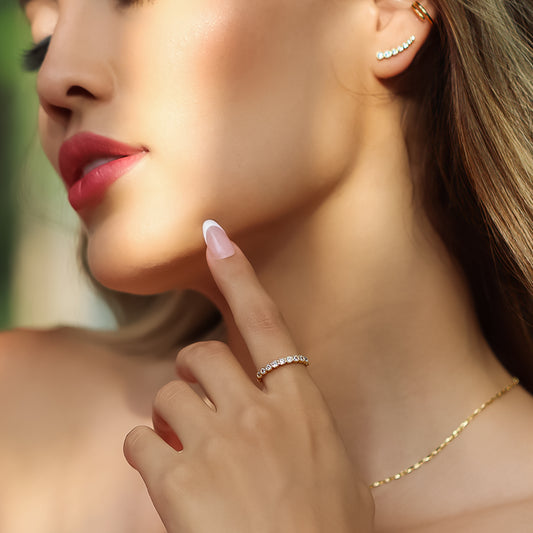 Mano de mujer con anillo en oro amarillo de 18 quilates con cristales de color blanco, hecho en Joyería Caracas. 
