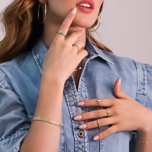 Mano de mujer con argolla de matrimonio en oro amarillo y blanco de 18 quilates con cristales de color blanco, hecho en Joyería Caracas. 