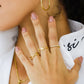 Mano de mujer con anillo de 2 líneas en forma de equis en oro amarillo de 18 quilates, hecho en Joyería Caracas. 
