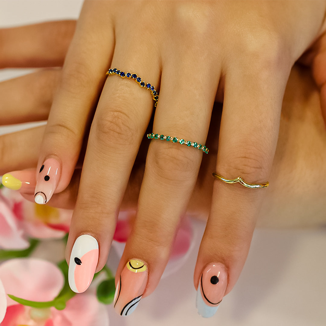 Mano de mujer con anillo en oro amarillo de 18 quilates con piedras preciosas de zafiros, hecho en Joyería Caracas. 