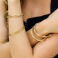 Mujer usando una pulsera en oro amarillo, blanco y rosa facetado de 18 quilates de Joyería Caracas.