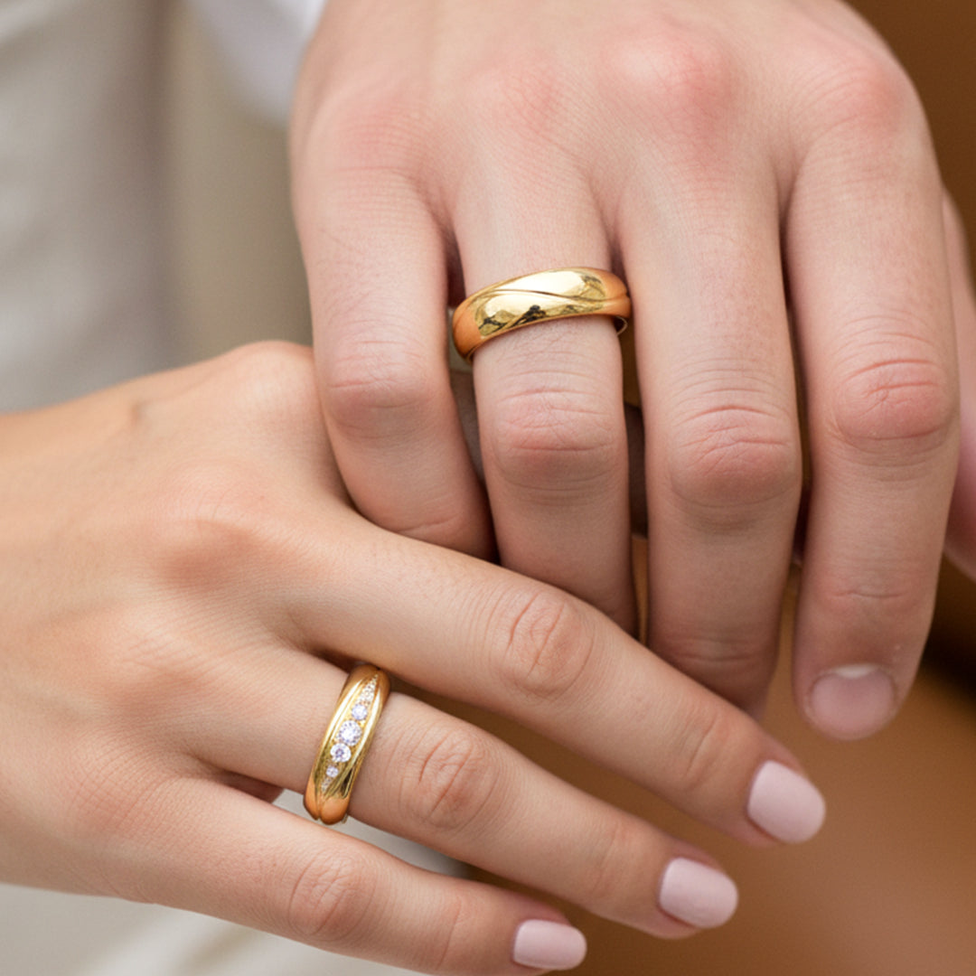 Mano de pareja en matrimonio usando unas argollas de matrimonio en oro amarillo de 18 quilates con cristales de Joyería Caracas. 