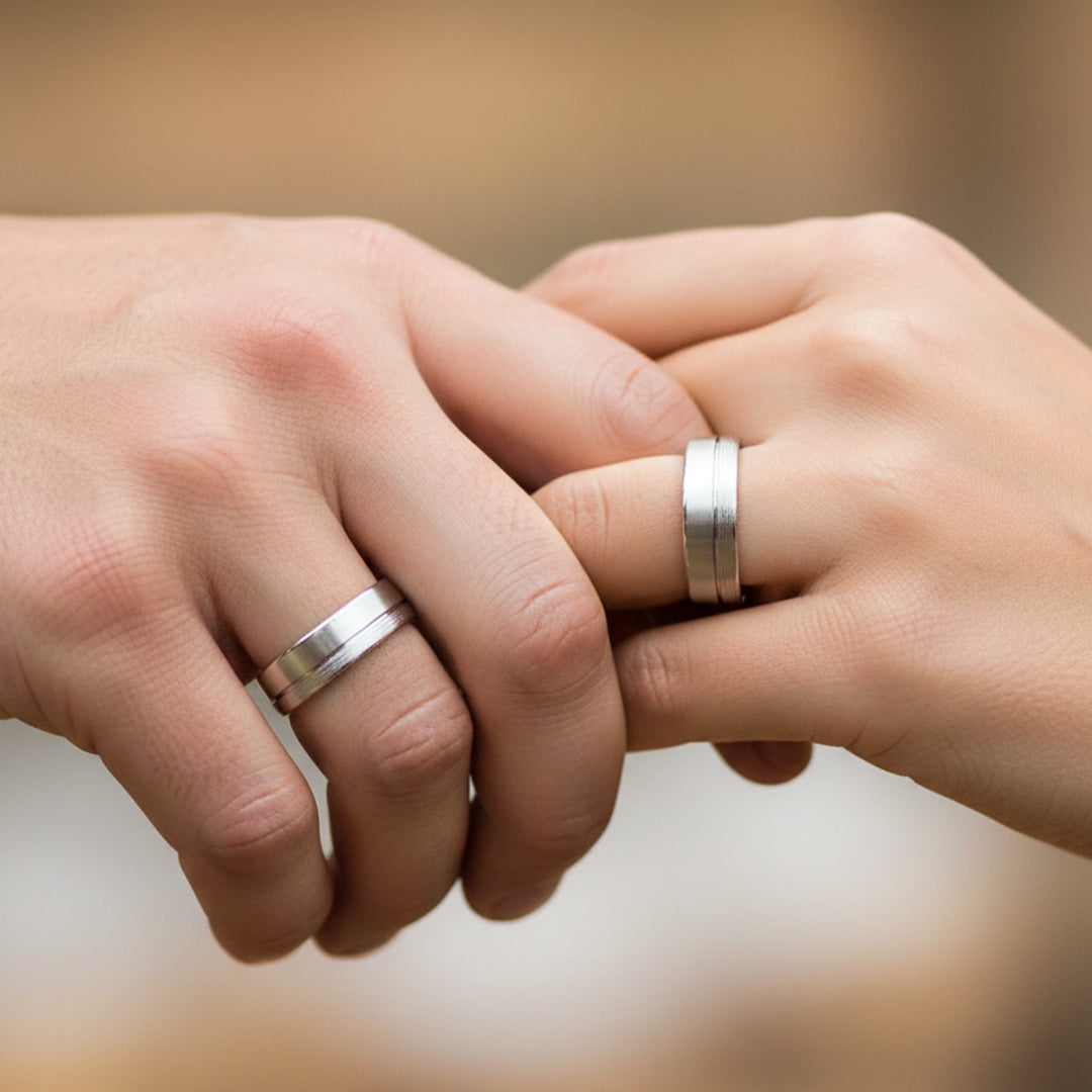 Mano de pareja usando unas argollas de matrimonio en oro blanco de 18 quilates de Joyería Caracas. 