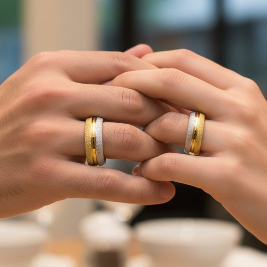 Mano de pareja usando unas argollas en oro amarillo y blanco facetadas de 18 quilates de Joyería Caracas. 