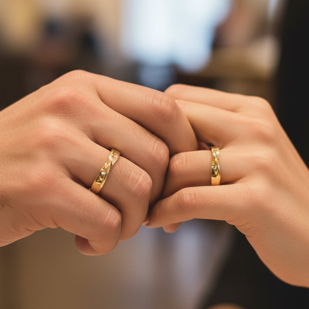 Mano de pareja usando unas argollas de matrimonio en oro amarillo de 18 quilates de Joyería Caracas. 