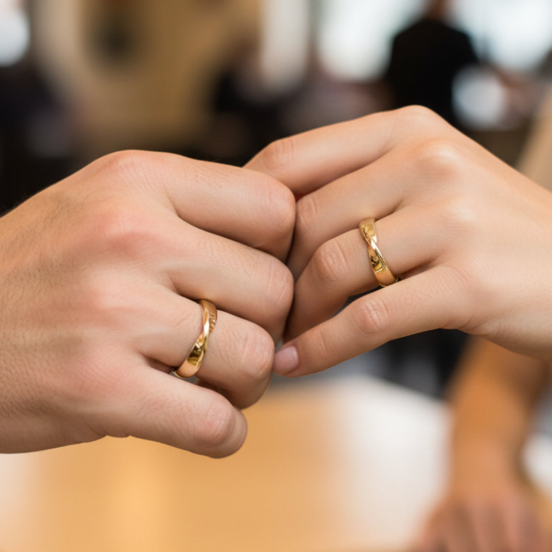 Mano de pareja usando unas argollas de matrimonio en oro amarillo de 18 quilates de Joyería Caracas. 