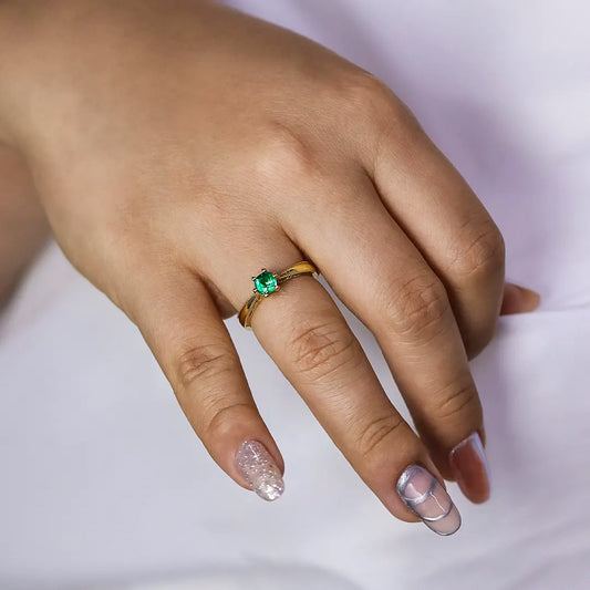 Mano de mujer con anillo en oro amarillo de 18 quilates con piedra preciosa esmeralda, hecho en Joyería Caracas. 
