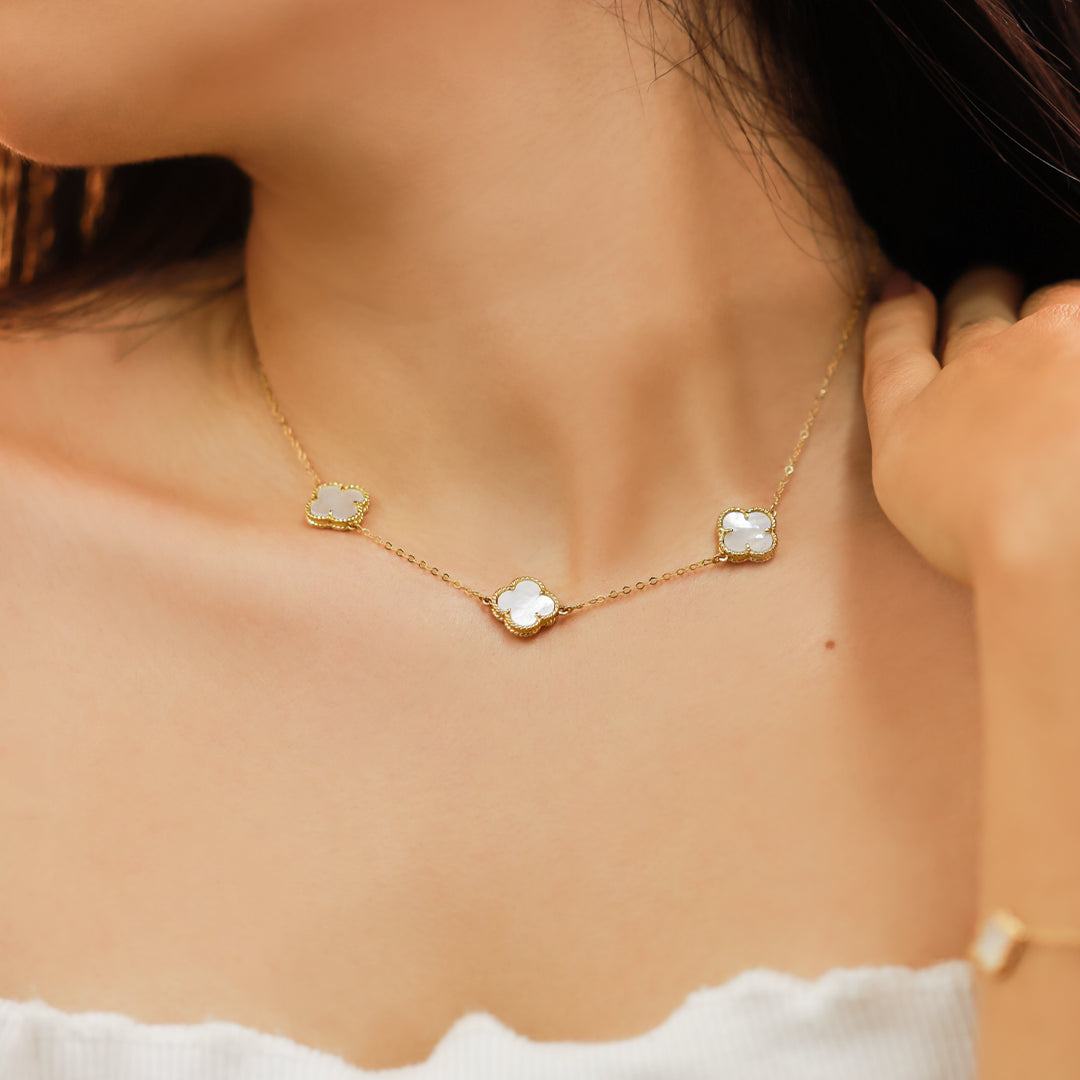 Cuello de mujer con gargantilla con formas de tréboles en oro amarillo de 18 quilates con delicados acabados en nácar, fabricado por Joyería Caracas. 