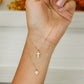 Mano de mujer con gargantilla doble con dije en forma de corazón y cruz en oro amarillo de 18 quilates.