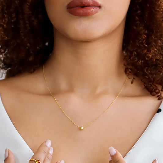 Cuello de mujer usando gargantilla mini cubana de 1 esfera facetada en oro amarillo de 18 quilates, hecho en Joyería Caracas. 