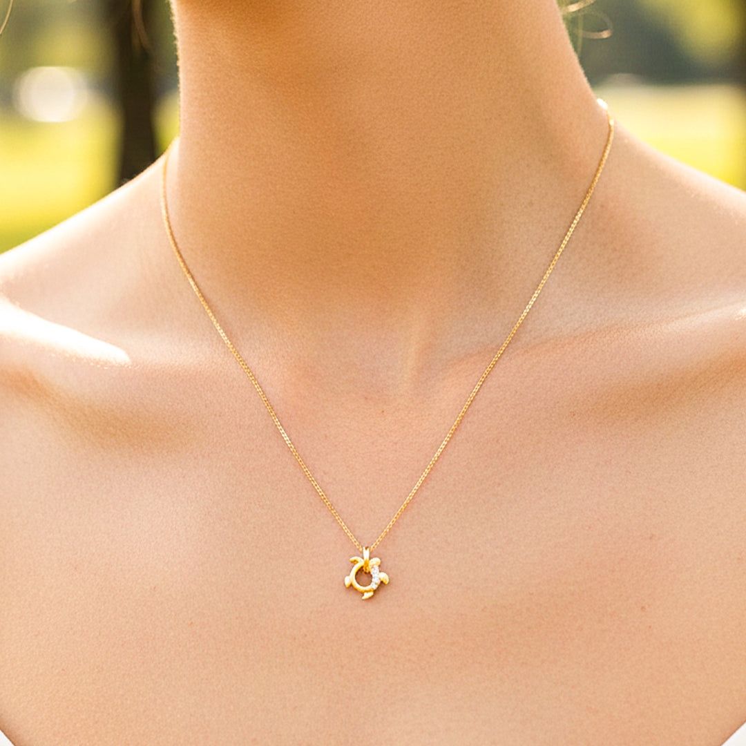 Cuello de modelo usando una gargantilla con dije en forma de tortuga en oro amarillo de 18 quilates con cristales de Joyería Caracas.