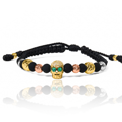 Pulsera Calavera - 3 Oros - Esmeraldas de Joyería Caracas está elaborada en oro 18k, con detalles en hilo terlenca y bisutería de calidad. Con garantía de por vida y sin costo adicional.