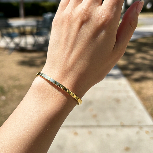 Mano de una modelo usando una pulsera aro en oro amarillo de Joyería Caracas.